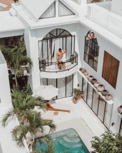 ein Paar steht auf dem Balkon eines Hauses mit Pool in der Unterkunft Villa Medina Canggu in Canggu