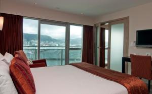 a hotel room with a bed and a large window at Copthorne Hotel Wellington, Oriental Bay in Wellington