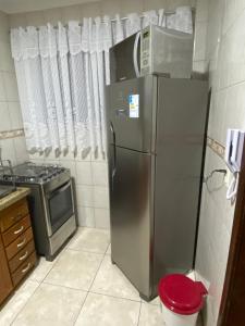 a kitchen with a stainless steel refrigerator and a stove at Apto com garagem no centro de Nova Friburgo in Nova Friburgo