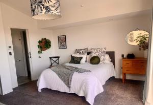 a bedroom with a bed with pillows on it at SEAduction Luxury Apartment in Napier