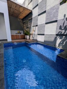 une grande piscine bleue à côté d'un immeuble dans l'établissement Cottonwood 4BR Villa Sutami with Pool Netflix BBQ, à Bandung