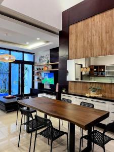 a large kitchen with a wooden table and chairs at Cottonwood 4BR Villa Sutami with Pool Netflix BBQ in Bandung