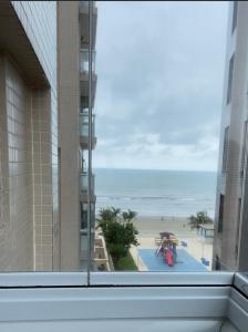 a view of the beach from the window of a hotel at Apartamento pé na areia in Itanhaém