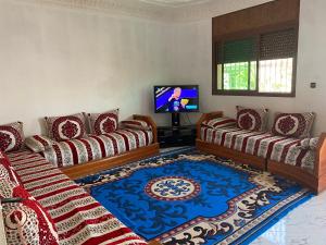 a living room with two couches and a tv at Appartement Villa Rayhana in Khenifra