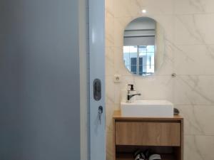 a bathroom with a sink and a mirror at Cottonwood Boutique Heritage Otten in Bandung