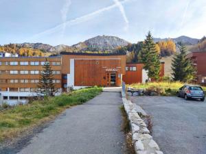 a building with a car parked in a parking lot at Studio divisible, ski aux pieds, vue sur pistes - FR-1-181-2677 in La Plagne Tarentaise