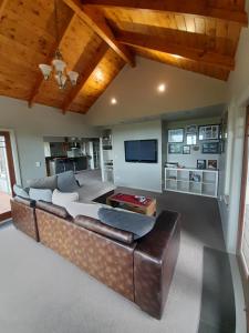 a living room with a couch and a tv at Georges BnB Nature and Lifestyle Retreat in New Plymouth