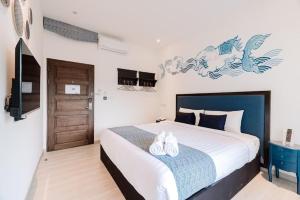 Un dormitorio con una cama con dos zapatos. en Sabai Hotel Aonang, en Ao Nang Beach