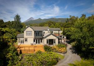 a home with a mountain in the background at Georges BnB Nature and Lifestyle Retreat in New Plymouth