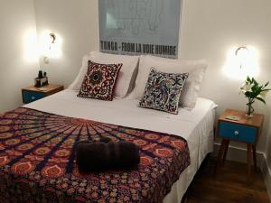 1 dormitorio con 1 cama grande con almohadas y 2 mesas en Studio Rio Beira Mar, en Río de Janeiro