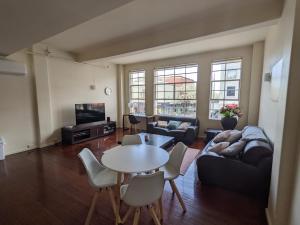 a living room with a table and a couch at 2 bedroom apartment in the heart of the city! in Bendigo
