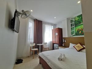 a bedroom with a bed and a television and a table at Sen Vàng Hotel in Xã Thang Tam