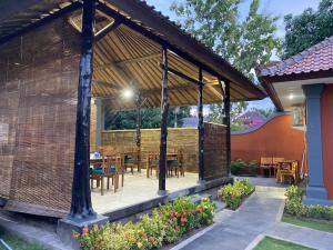 a pavilion with tables and chairs on a patio at Badini Homestay Pemuteran Bali in Pemuteran