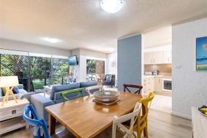 a kitchen and living room with a table and chairs at Bay Parklands, 29 2 Gowrie Avenue - views, air conditioning, Wi-Fi, Pool, tennis court and spa in Nelson Bay