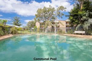 uma piscina em frente a uma cerca em Bay Parklands, 29 2 Gowrie Avenue - views, air conditioning, Wi-Fi, Pool, tennis court and spa em Nelson Bay