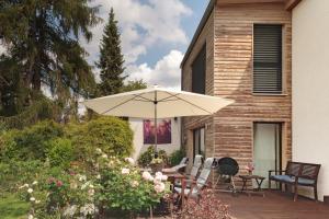 un patio con mesa y sombrilla en Zuhause im Paradies en Hannover