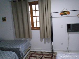 um quarto com um frigorífico e uma janela em Cantinho Bonsai no Rio de Janeiro