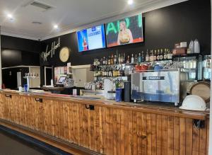a bar in a restaurant with a counter and a tv at Woomargama Motel in Woomargama