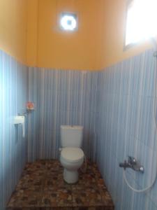 ein Bad mit einem weißen WC in einem Zimmer in der Unterkunft Alola inn in Padangbai