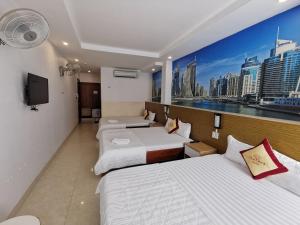 a hotel room with three beds and a tv at Sen Vàng Hotel in Xã Thang Tam