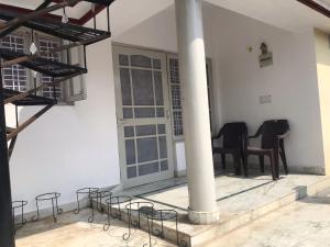 Zimmer mit Stühlen, einer Säule und einem Tisch in der Unterkunft Welcome Hostel in Dehradun