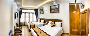 ein Hotelzimmer mit zwei Betten und einem Fenster in der Unterkunft TÙNG LÂM HOTEL in Hạ Long