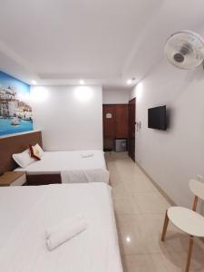 a hotel room with two beds and a tv at Sen Vàng Hotel in Xã Thang Tam +29 photos