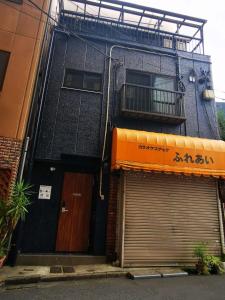 un edificio con 2 puertas de garaje y balcón en Leisure hotel 中野, en Tokio