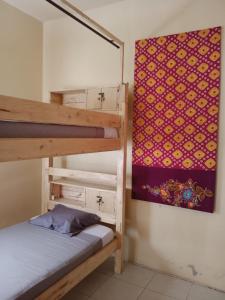 a bedroom with a bunk bed and a painting on the wall at Barracuda Beach Hostel in Amed