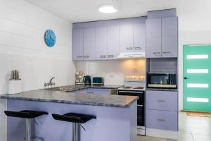 a kitchen with white cabinets and black appliances at Iluka Villa 4 in Iluka