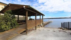 a wooden gazebo next to a body of water at Iluka Villa 4 in Iluka