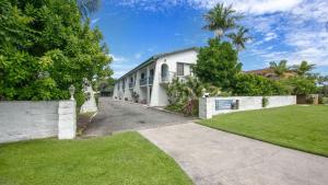 un bâtiment blanc avec une clôture et une cour dans l'établissement Iluka Villa 10, à Iluka