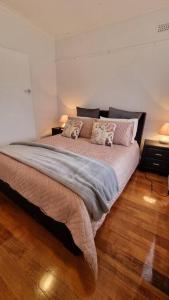 Un dormitorio con una cama grande con almohadas. en 3 bedroom Art Deco home with modern features, en Burnie