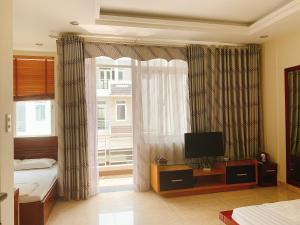 a bedroom with a bed and a television and a window at RosePark Tuan Chau in Ha Long