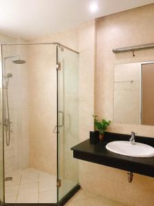 a bathroom with a glass shower and a sink at RosePark Tuan Chau in Ha Long