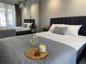 1 dormitorio con 1 cama con velas y copas de vino en URBAN APARTMENTS PREMIUM DOWNTOWN Opolska 10 No 89 with GARAGE, en Katowice