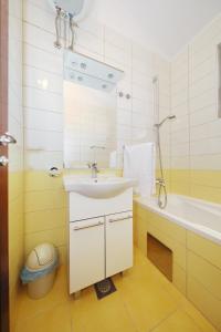 a bathroom with a sink and a tub and a mirror at Apartments by the sea Ribarica, Karlobag - 15907 in Ribarica