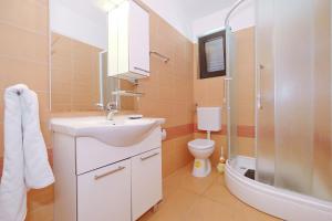 a bathroom with a sink and a toilet and a shower at Apartments by the sea Ribarica, Karlobag - 15907 in Ribarica