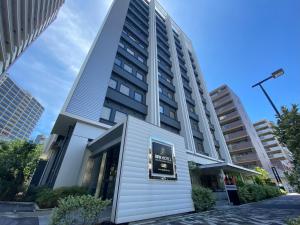 a building with a sign in front of it at APA Hotel Keikyukamata Ekimae in Tokyo