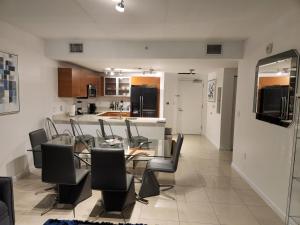 a dining room and kitchen with a glass table and chairs at Wonderful 1 bedroom condo in Midtown. in Miami