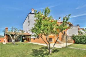 duży dom z drzewem na podwórku w obiekcie Apartments with a parking space Umag - 15941 w mieście Umag