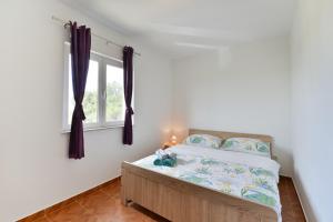 a bedroom with a bed and a window at Apartments with parking space Vrsi, Zadar - 15944 in Vrsi