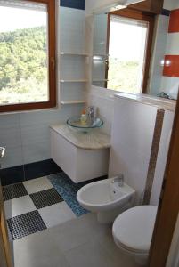 łazienka z umywalką, toaletą i oknem w obiekcie Holiday house with a swimming pool Stomorska, Solta - 15950 w mieście Grohote