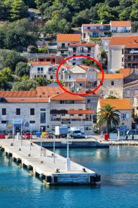 ein Pier im Wasser mit einem roten Kreis in der Unterkunft Apartments by the sea Vis - 15926 in Vis