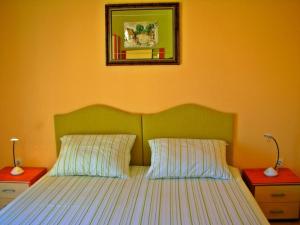 Apartments by the sea Vis - 15926 في فيس: غرفة نوم مع سرير مع اللوح الأمامي الأخضر ومرآة