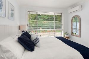 Un dormitorio con una gran cama blanca y una ventana en Danalene Parade 2 58 Corlette, en Corlette