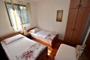 um pequeno quarto com 2 camas e uma janela em Apartments by the sea Rogac, Solta - 16223 em Grohote