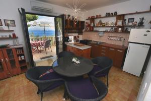 a kitchen with a table and chairs and a view of the ocean at Apartments by the sea Rogac, Solta - 16223 in Grohote