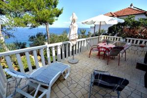 a patio with a table and chairs and an umbrella at Apartments by the sea Rogac, Solta - 16223 in Grohote