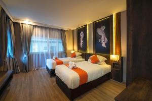 ein Hotelzimmer mit 2 Betten und einem Fenster in der Unterkunft The Cliff Elegance Resort in Ao Nang Beach